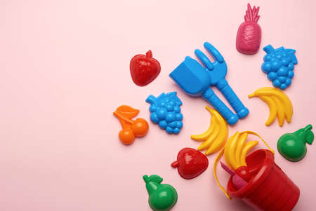 plastic childrens toys in the form of fruit and a bucket on a pink background, copy spaceの写真素材