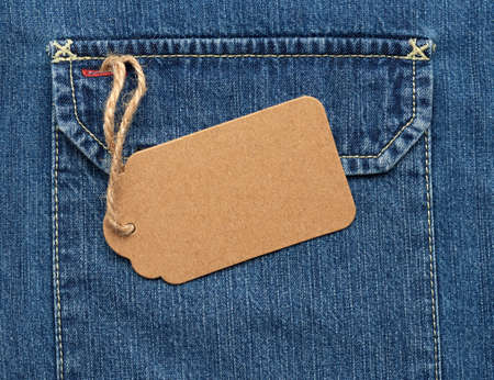 empty brown paper tag on a rope tied to blue jeans, full frameの写真素材