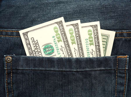 paper hundred United States dollar bills in the back pocket of jeans, close upの写真素材