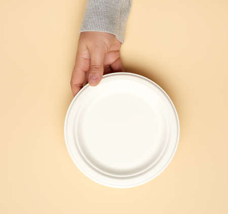 white paper disposable plate on a beige background, top view. The concept of rejection of plastic, environmental conservationの写真素材