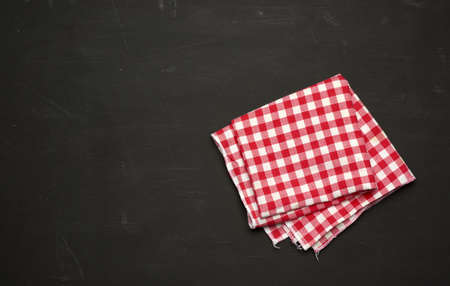 red-white textile kitchen towel on a black wooden background, top view, copy spaceの写真素材