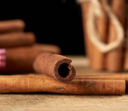 dry brown cinnamon sticks on wooden background, close upの写真素材