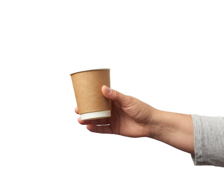 female hand holds paper brown disposable cup for coffee and tea, part of body isolated on white backgroundの写真素材