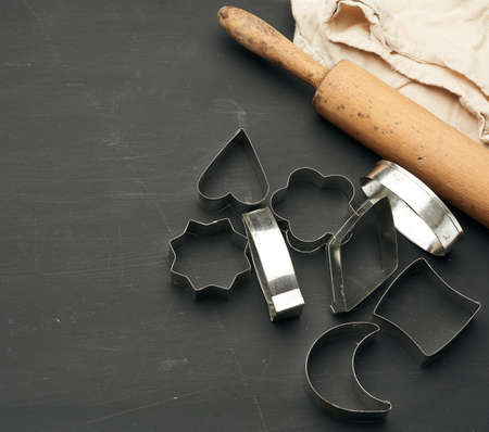 vintage metal molds for making cookies and wooden rolling pin on a black wooden background, top viewの写真素材