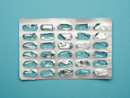 blank blister pack of capsule pills on a blue background, top view