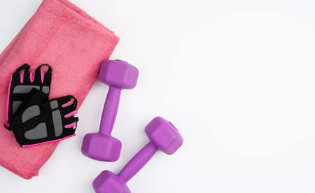 gloves, pair of purple dumbbells and pink towel on a white background, top view, copy spaceの写真素材