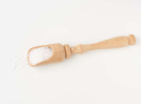 large crystals of white sea salt in a brown wooden spoon, top viewの写真素材