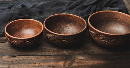 empty brown ceramic plates on a wooden table, top viewの写真素材