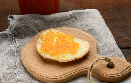 sandwich with red salmon caviar on a wooden board, top viewの写真素材
