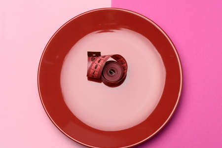 twisted red centimeter in a red plate, top viewの写真素材