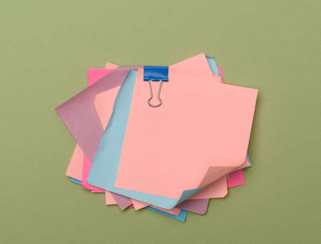 stack of colorful paper stickers on green background, close up