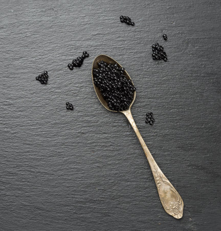 caviar of paddlefish fish in a spoon, black background, top viewの写真素材