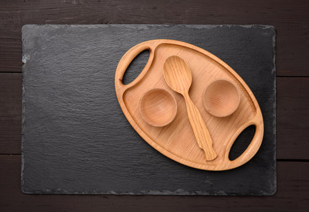 empty oval brown wooden tray board on a black background, top viewの写真素材