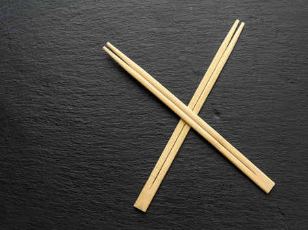 two wooden sticks for sushi on a black background, top viewの写真素材