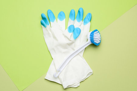 white rubber gloves for cleaning, brushes on a green background, flat layの写真素材