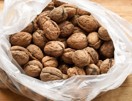 walnut in a plastic bag on a wooden table, top viewの写真素材