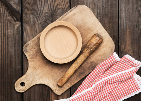 empty plate and old brown rectangular wooden kitchen cutting board on the table, top viewの写真素材