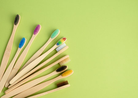 multicolored wooden toothbrushes on a green background, plastic rejection concept, zero waste, top viewの写真素材