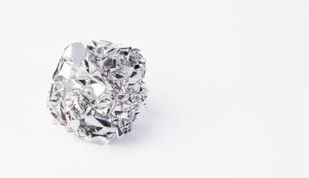 crumpled piece of gray foil on a white background, copy spaceの写真素材