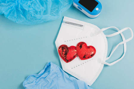 disposable white medical mask, oximeter on blue background, top view