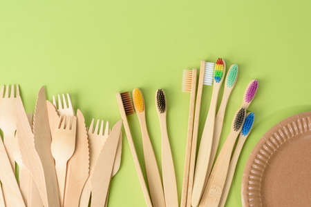 toothbrushes and wooden fork and empty round brown disposable plate made from recycled materials on...