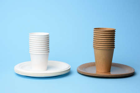 stack of white and brown paper cups and round plates on a blue background, zero wasteの写真素材