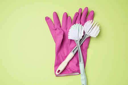 purple rubber gloves for cleaning, brushes on a green background, flat layの写真素材