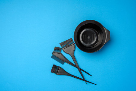 bowl and black plastic brushes for hair coloring on a blue background, setの写真素材