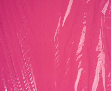 texture of crumpled transparent polyethylene on a pink background, full frameの写真素材