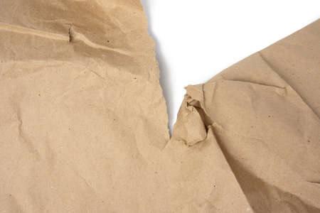 large piece of crumpled brown paper with torn edge isolated on white background, close upの写真素材
