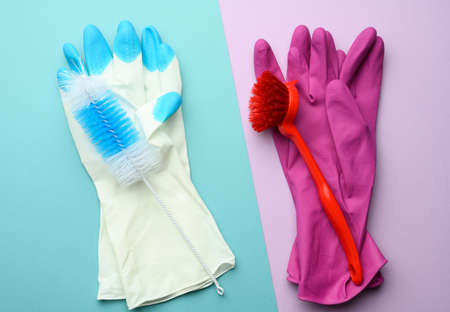 pink and white rubber gloves for cleaning, brushes on a blue background, flat lay