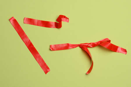 pieces of red rubber tape on a green background, top view