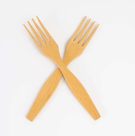 pair of wooden forks on white background, close up