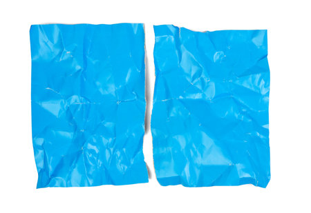crumpled blue cardboard sheet of paper isolated on white background, a4 sheet torn in halfの写真素材