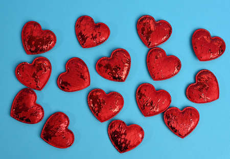 red textile small hearts on blue background, festive background, top viewの写真素材