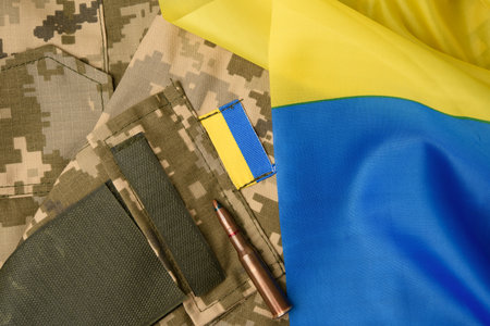 fragment of the sleeve of the uniform of the Ukrainian soldier with the flag of ukraine and patron, full frameの写真素材