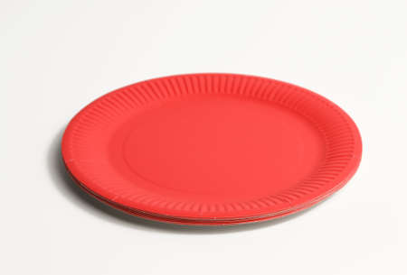 empty red paper disposable plates on a white background, top view. The concept of rejection of...
