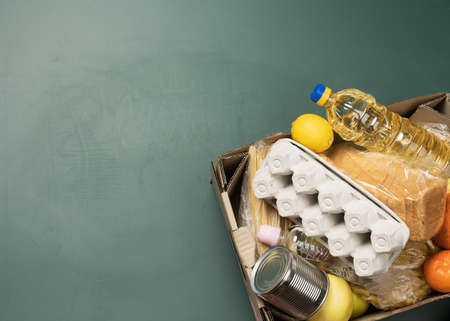 cardboard box with various products, fruits, pasta, sunflower oil in a plastic bottle and preservation. Donation concept, top viewの写真素材