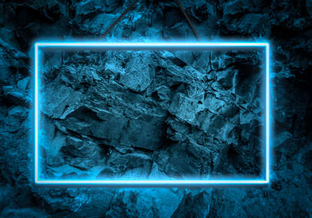 blue neon glowing frame on a background of a layer of stones, copy space
