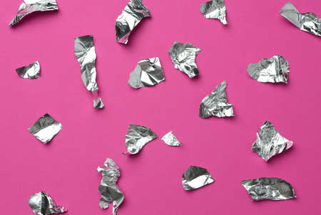 torn pieces of foil on a pink background, top viewの写真素材