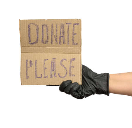 hand holding a brown piece of cardboard with the inscription please donate on a white backgroundの写真素材