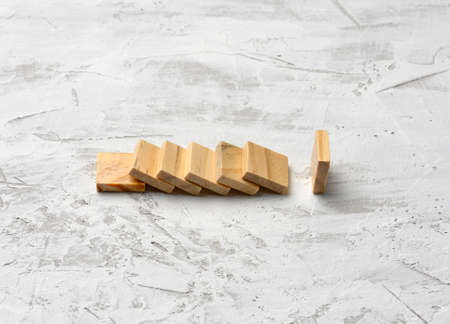 wooden empty squares stand on a white background, a row has fallen and one stands
