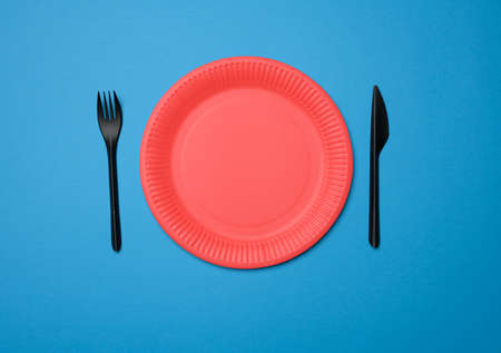 empty red paper disposable plates on a blue background, top view