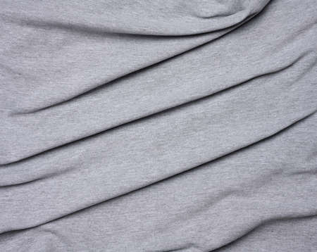 mottled gray cotton fabric for clothing, fabric creased, close upの写真素材