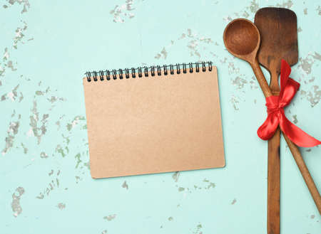 spoon and spatula tied with blue ribbon on green background, top viewの写真素材