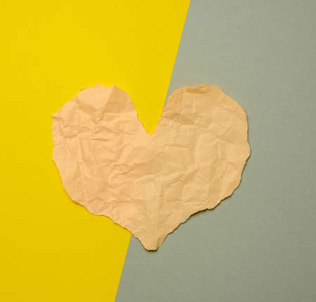 heart made of torn paper on a gray-yellow background, top viewの写真素材