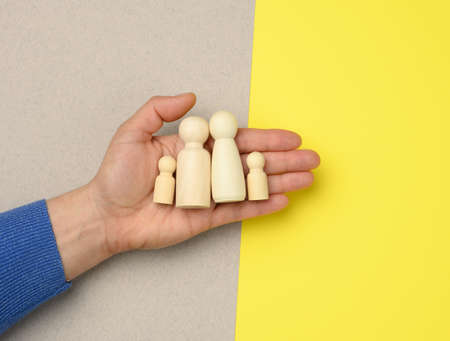 female hand holding wooden figurines in the palm, familyの写真素材