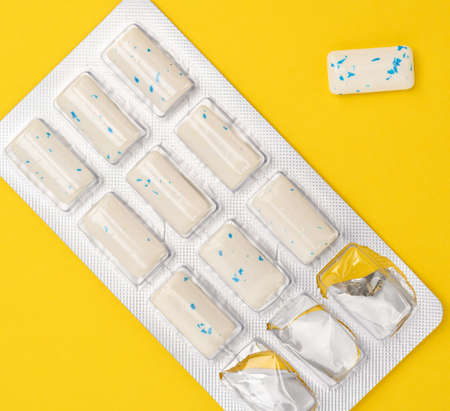 rectangular pieces of gum in a blister pack on a yellow background, top viewの写真素材