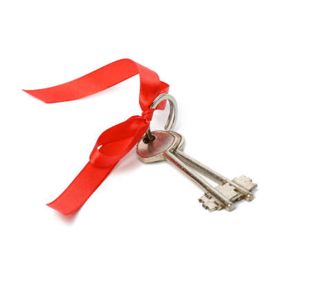 two metal house door keys with red ribbon isolated on white background, real estate purchase conceptの写真素材