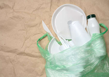 plastic waste from life on the background of brown kraft paper, environmental pollution, top view